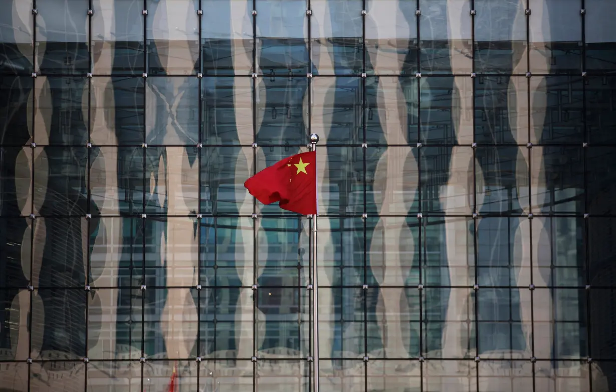 Chinese national flag flutters at the headquarters of a commercial bank on a financial street near the headquarters of the People's Bank of China, China's central bank, in central Beijing