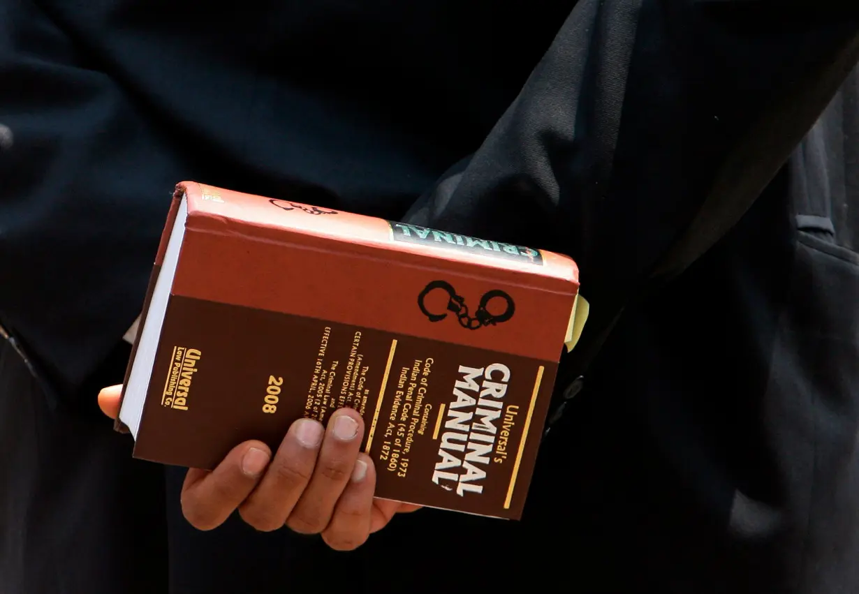 Lawyer holds a book as he waits to enter the Arthur Road jail in Mumbai