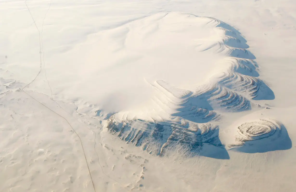 A road and the Trans Alaska Pipeline run past a mountain in northern Alaska