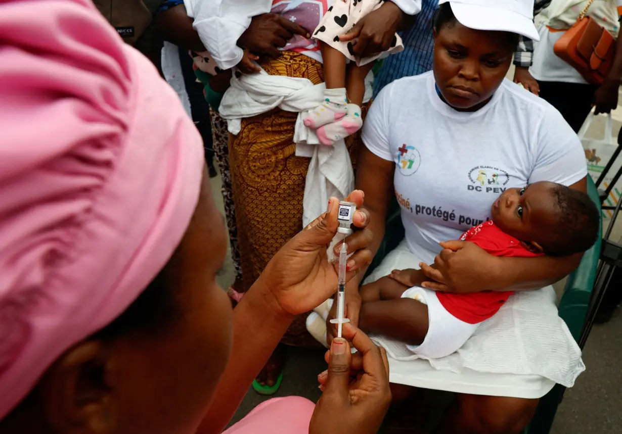 A health employee prepares to give a malaria injection to a child during the official ceremony for the launch of a malaria vaccination campaign in Ivory Coast.