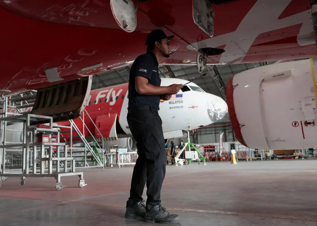 A technician works on aircraft in the maintenance hangar of Asia Digital Engineering at Subang