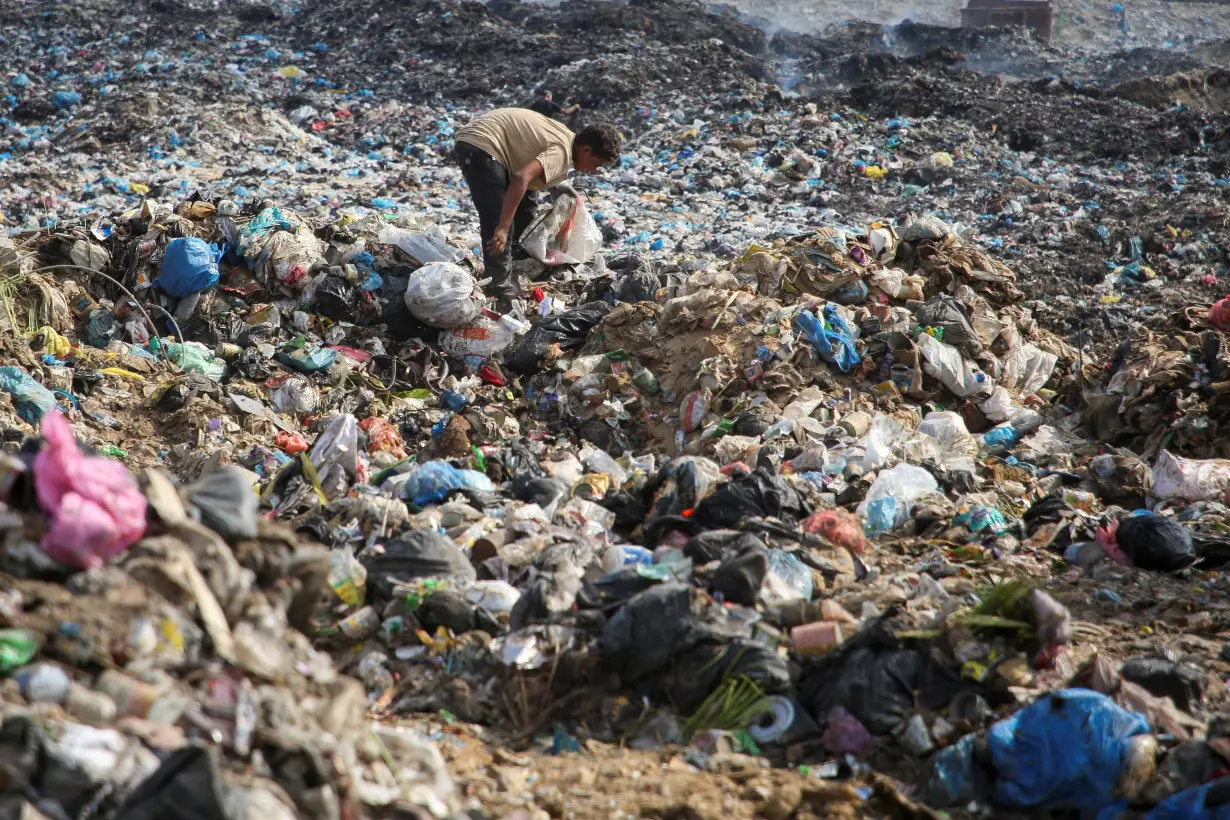 Palestinians scavenge for usable items at a dump site, amid the Israel-Hamas conflict, in Khan Younis in the southern Gaza Strip