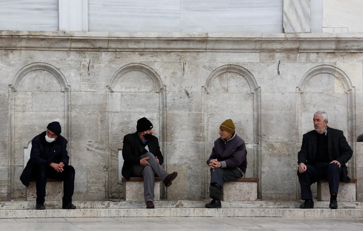 FILE PHOTO: Men rest at the courtyard of Fatih Mosque in Istanbul,