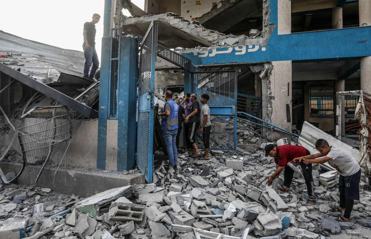 Palestinians and UN workers examine the destroyed UNRWA school in Nuseirat refugee camp of Deir al-Balah, Gaza on July 15.