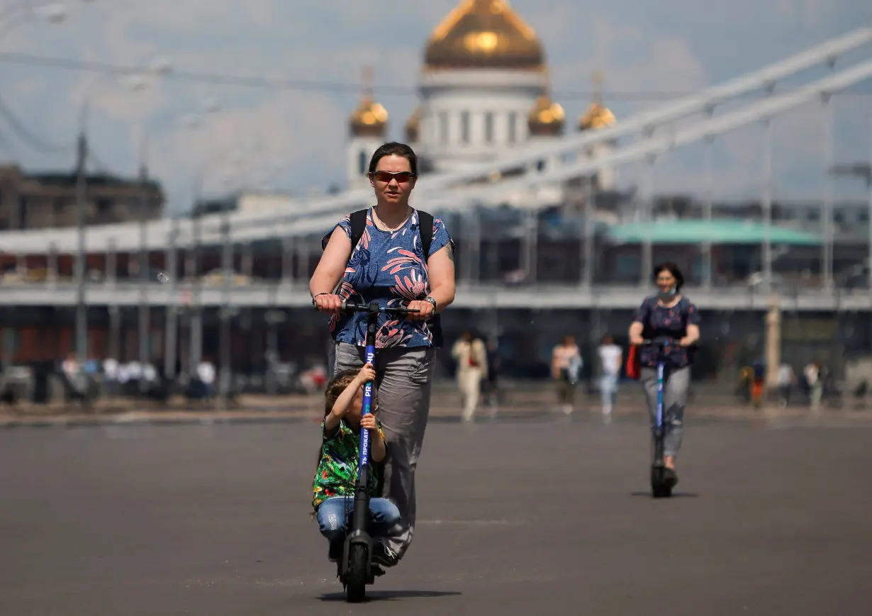 FILE PHOTO: People ride electric scooters in Moscow