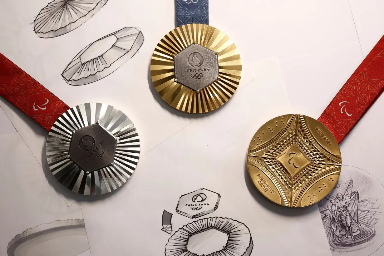 A Paris 2024 Olympic Games gold medal (top) is seen on display with Paralympic Games gold (right) and silver medals (left).