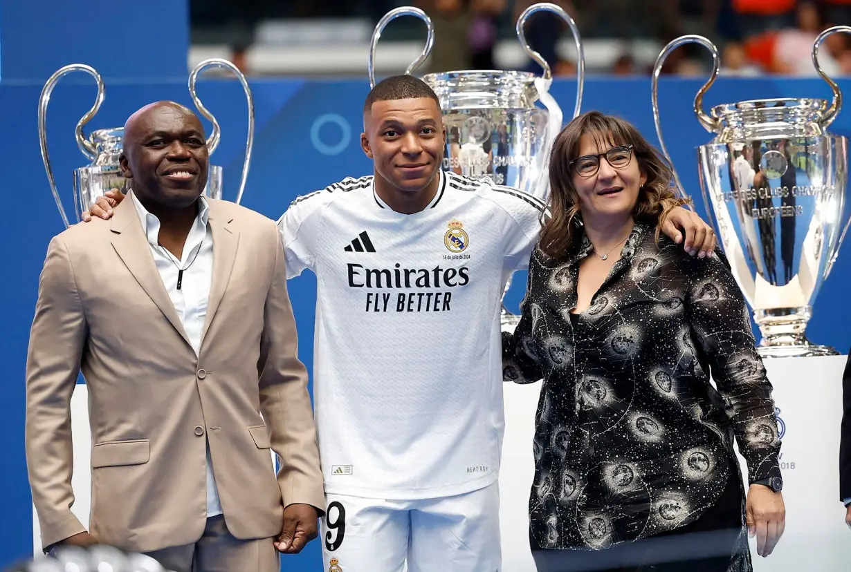 Kylian Mbappe poses with his parents inside the Santiago Bernabéu.