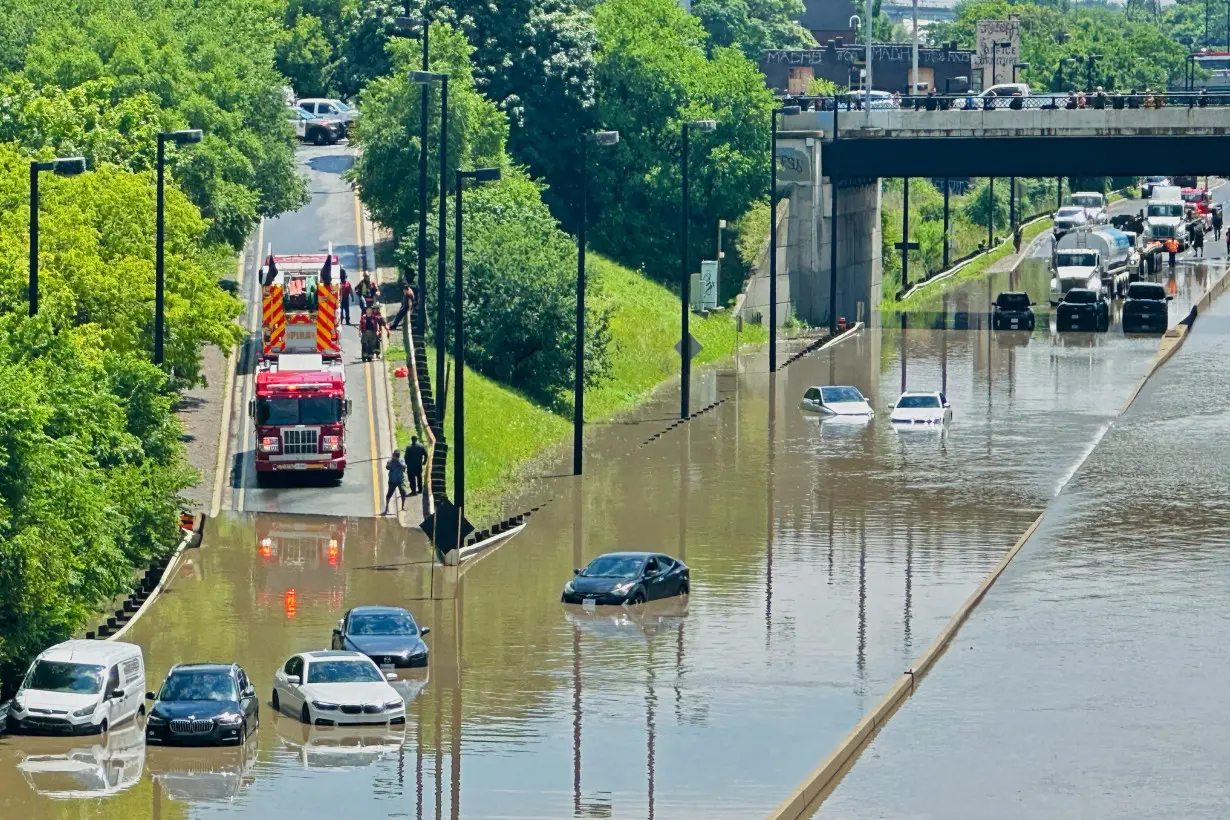 A cyclist views a flooded section of the Don Valley Parkway after heavy rains hit Toronto