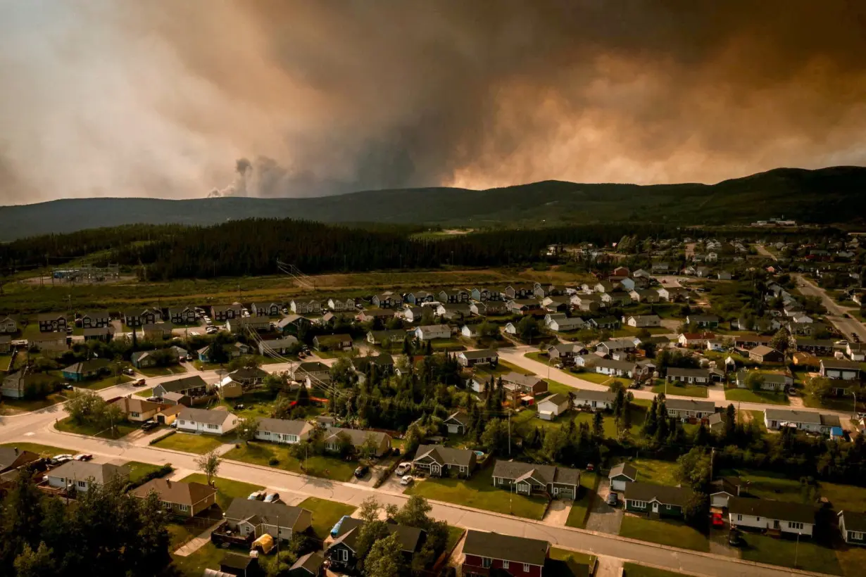 FILE PHOTO: Smoke from an encroaching wildfire is seen over homes after an evacuation was ordered in the eastern Canadian community of Labrador City