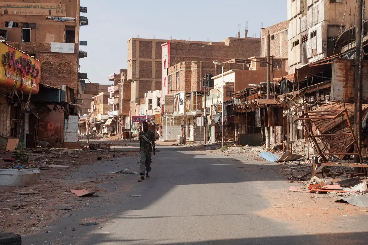 FILE PHOTO: A member of the Sudanese Armed forces walks between damaged buildings, in Omdurman