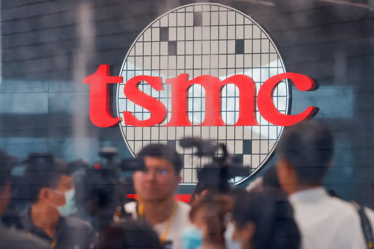 FILE PHOTO: Taiwan Semiconductor Manufacturing Company's (TSMC) logo is seen while people attend the opening of the TSMC global R&D center in Hsinchu