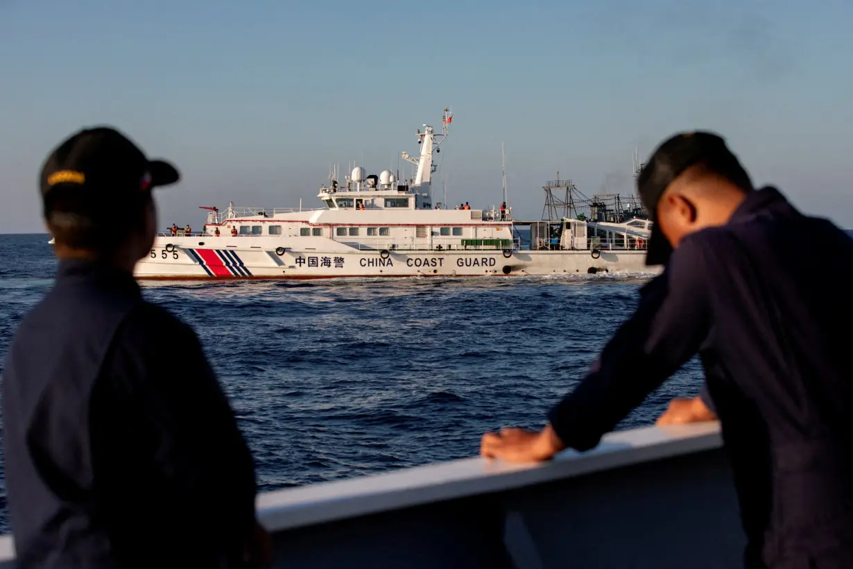 Members of the Philippine Coast Guard stand alert as a Chinese Coast Guard vessel blocks their way to a resupply mission at Second Thomas Shoal in the South China Sea