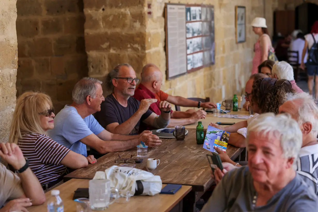 Greek Cypriots and Turkish Cypriots drink coffee and talk in the courtyard of a 16th century Ottoman inn in Cyprus's ethnically split capital Nicosia