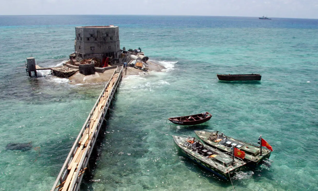 FILE PHOTO: Motorboats anchor at a partially submerged island of Truong Sa islands