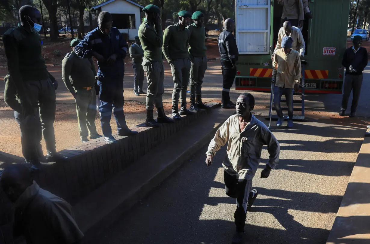 Opposition leader Jameson Timba walks after disembarking a prison truck as he arrives for bail application at the Harare Magistrates' court