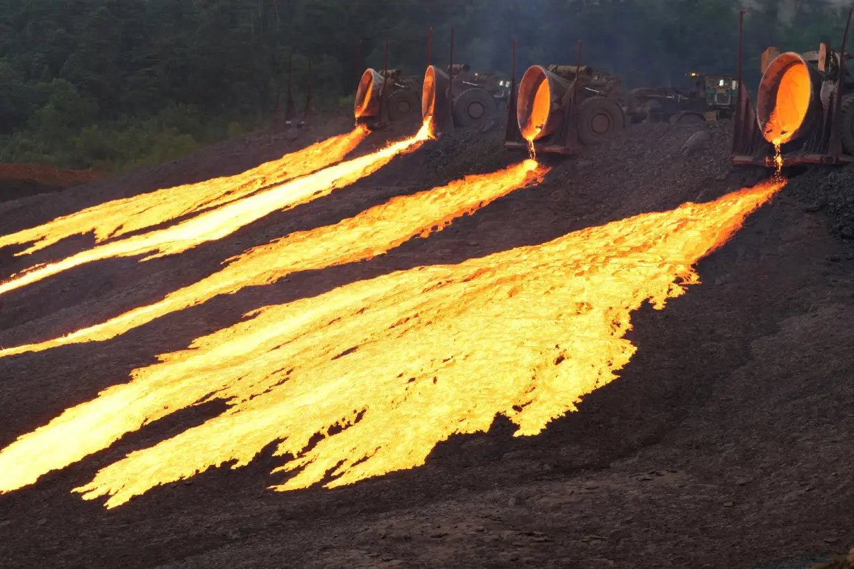 Hot slag flows from trucks to the dumping site at the nickel processing plant operated by PT Vale Indonesia in Sorowako