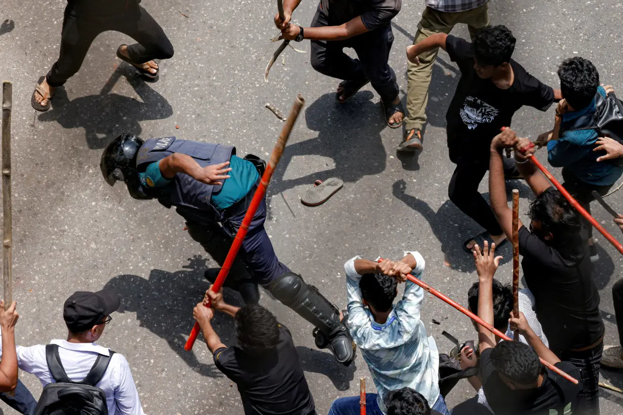 A police officer is beaten by mob during a clash between anti-quota supporters, police and Awami League supporters at the Rampura area in Dhaka