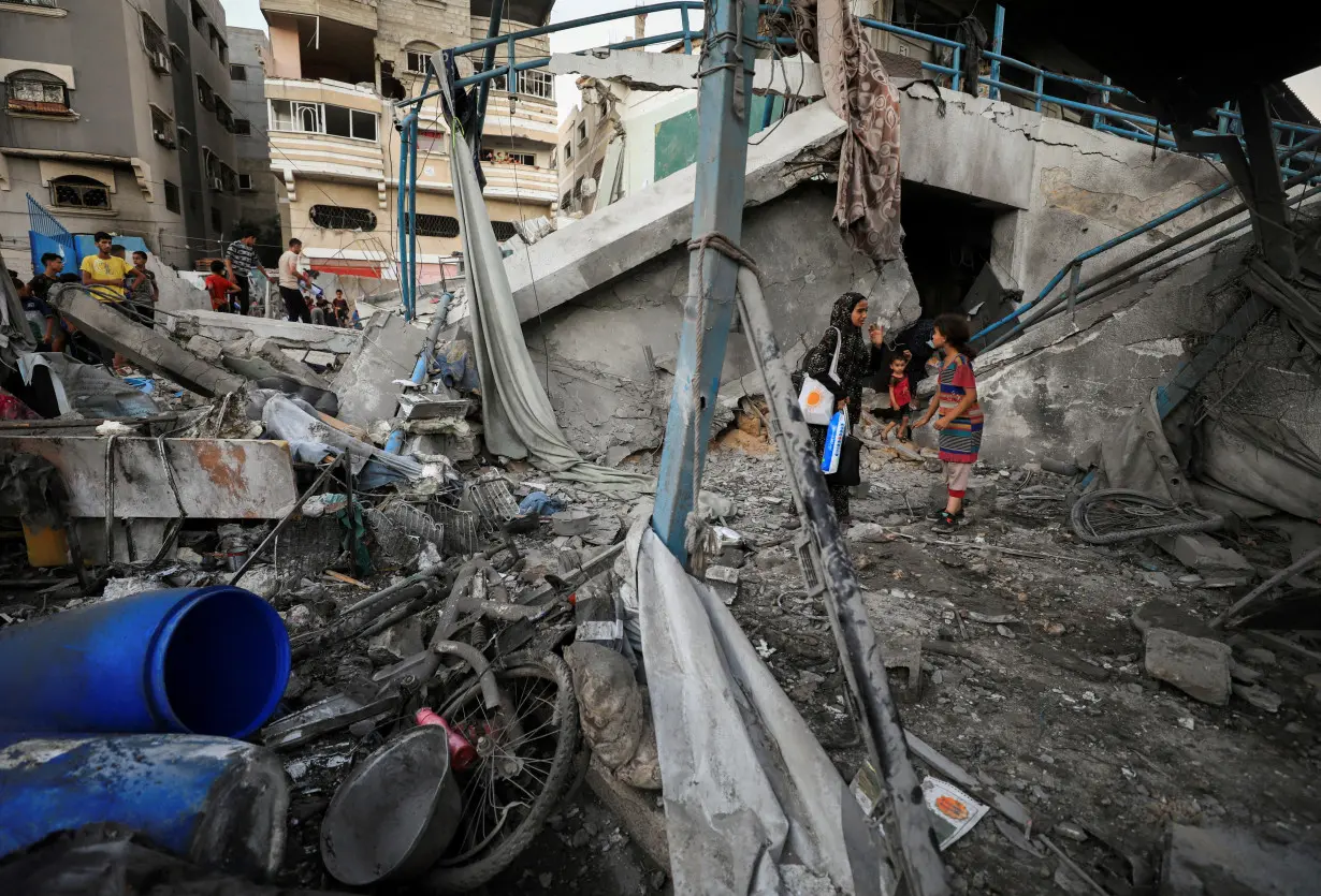 Palestinians gather at a UN school sheltering displaced people, following an Israeli strike, amid Israel-Hamas conflict, in Gaza City