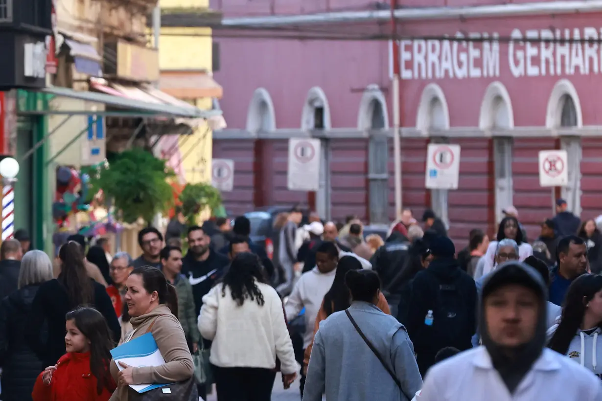 People walk along a street, in Porto Alegre