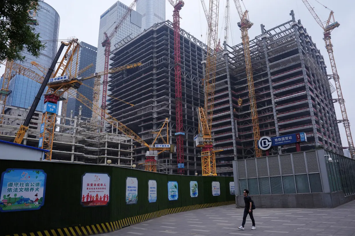 FILE PHOTO: Person walks past a construction site in Beijing's Central Business District