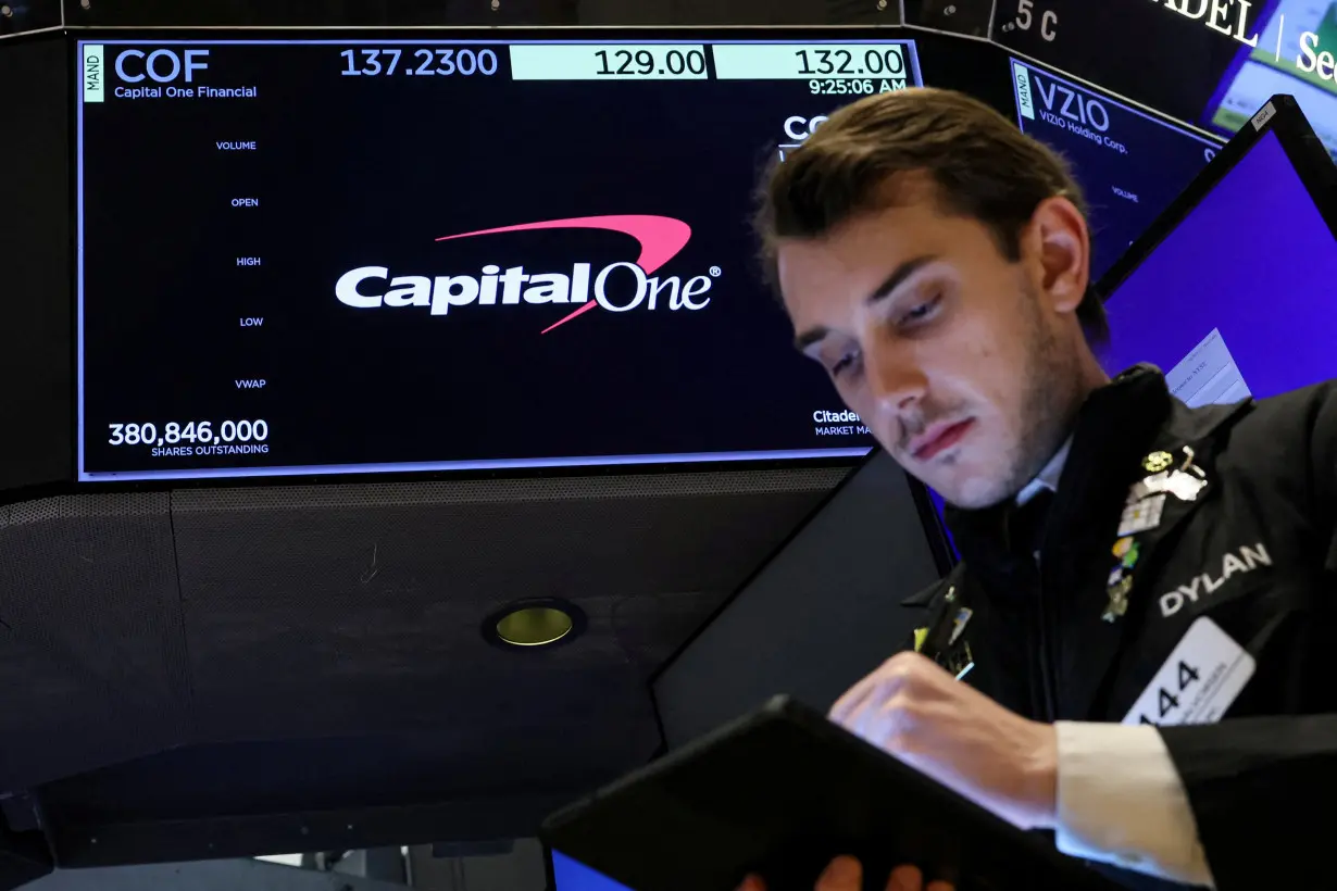 FILE PHOTO: A screen displays the logo and trading information for Capital One Financial as a trader works on the floor at the NYSE in New York