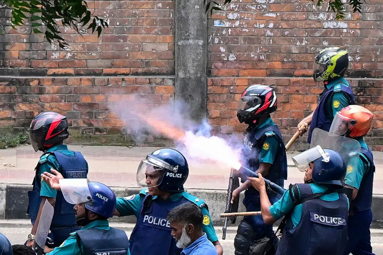 Bangladeshi police fire tear gas to disperse protesters during a clash in Dhaka on July 18.