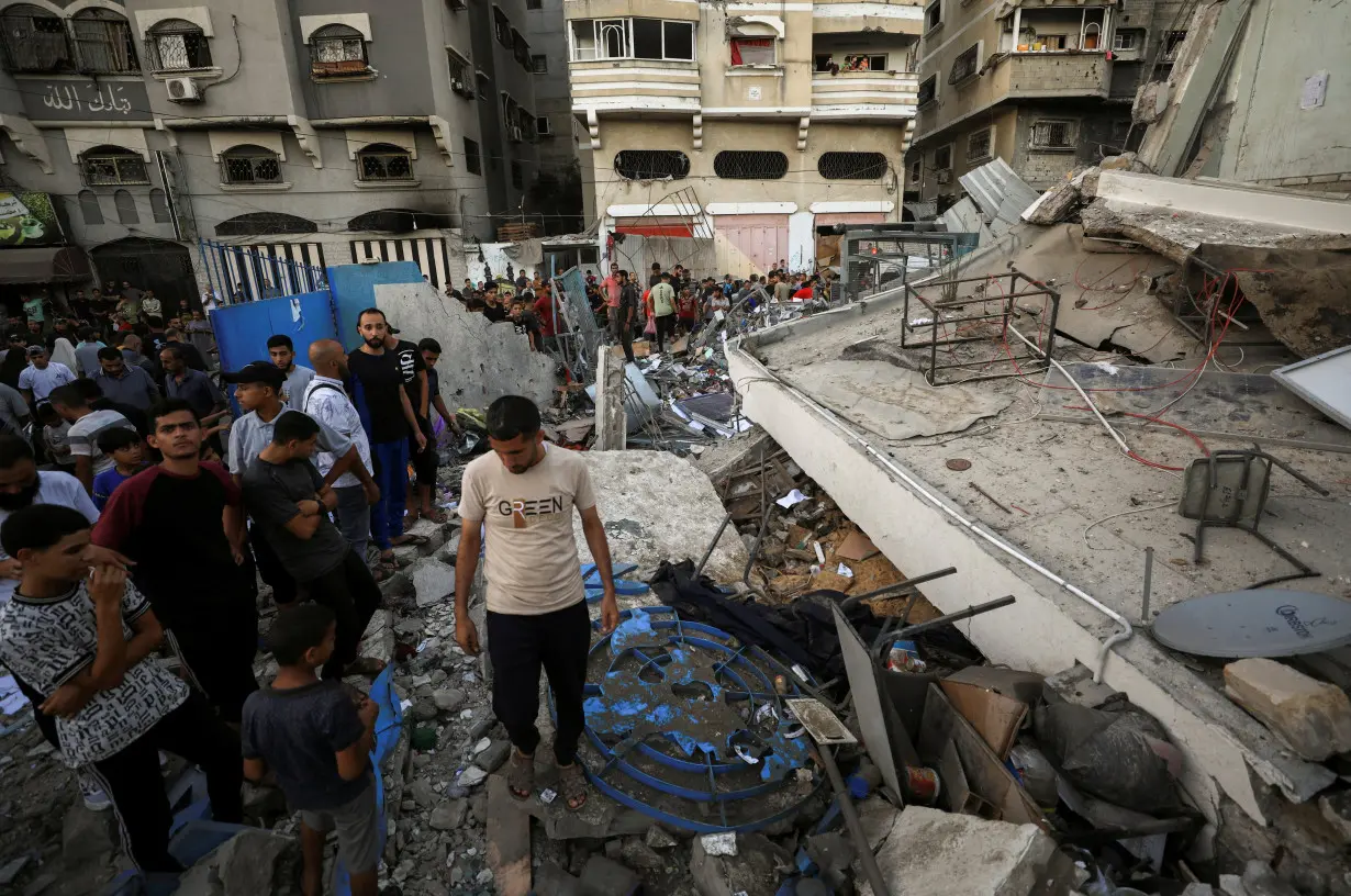 Palestinians gather at a UN school sheltering displaced people, following an Israeli strike, amid Israel-Hamas conflict, in Gaza City