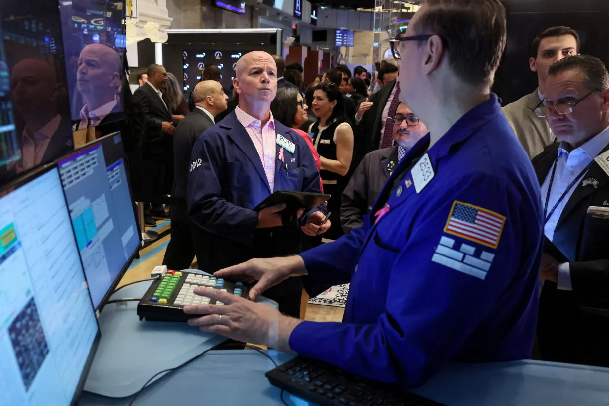 FILE PHOTO: Traders work on the floor of the NYSE in New York