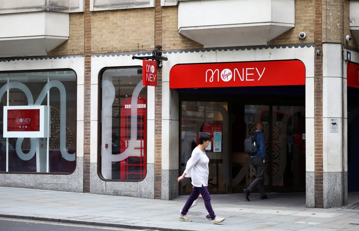 People walk past a Virgin Money store in central London