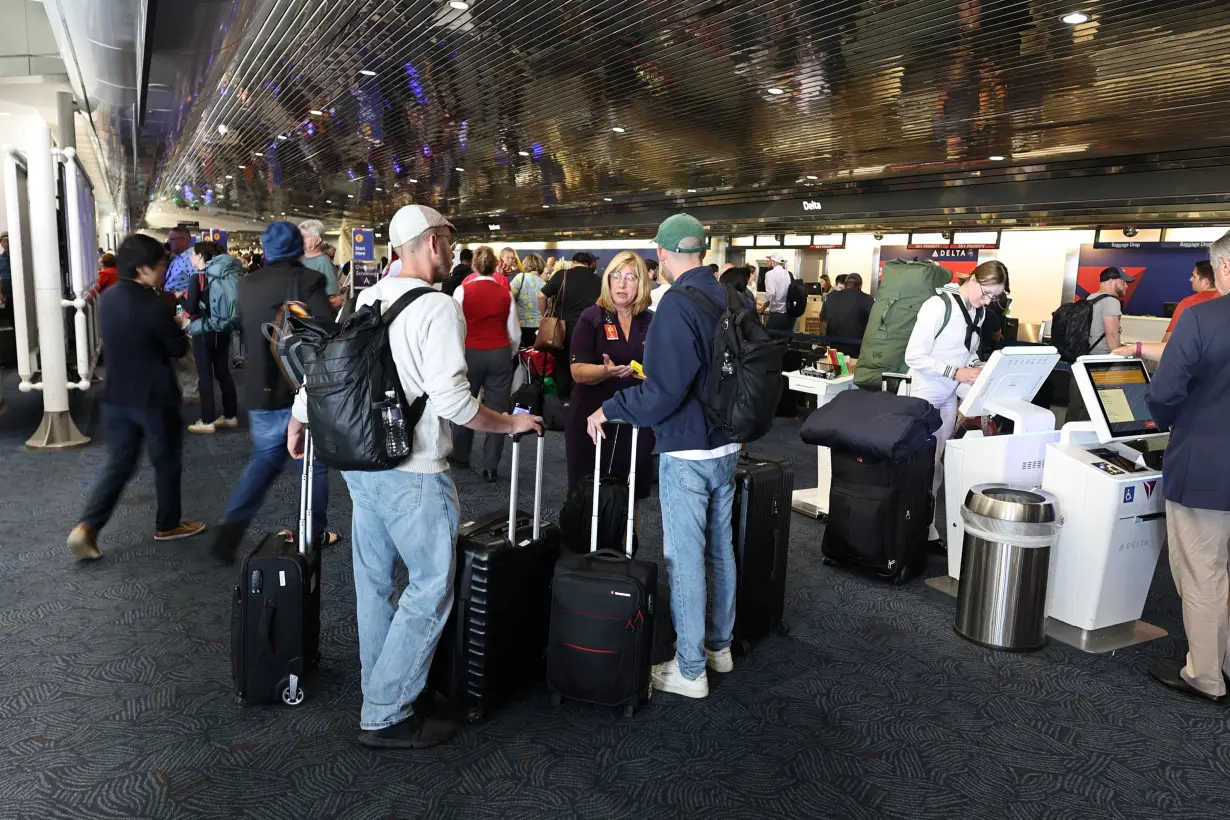 Travelers line up at Milwaukee General Mitchell International Airport due to a worldwide tech outage caused by an update to CrowdStrike's 