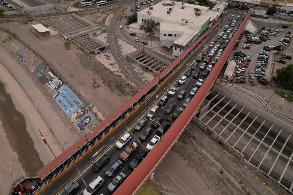 Cars line up to cross into the United States, after a global technological disruption that caused a delay at the international crossing, in Ciudad Juarez