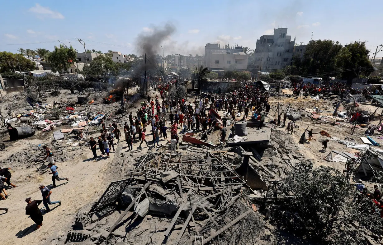 Palestinians gather near damaged buildings, following what Palestinians say was an Israeli strike at a tent camp in Al-Mawasi area in Khan Younis in the southern Gaza Strip, July 13.