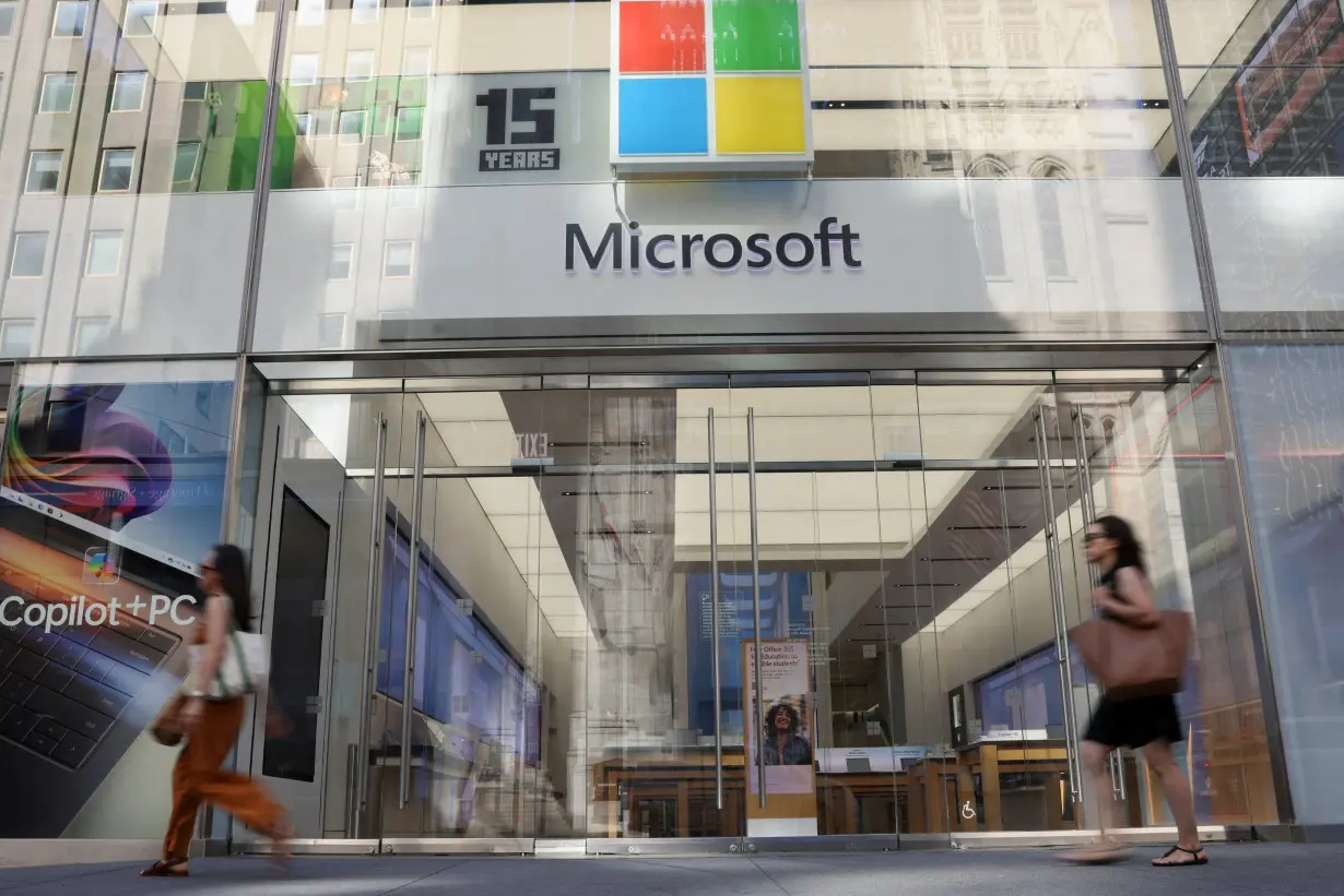 Pedestrians walk past a Microsoft Experience Center, following a global IT outage, in New York