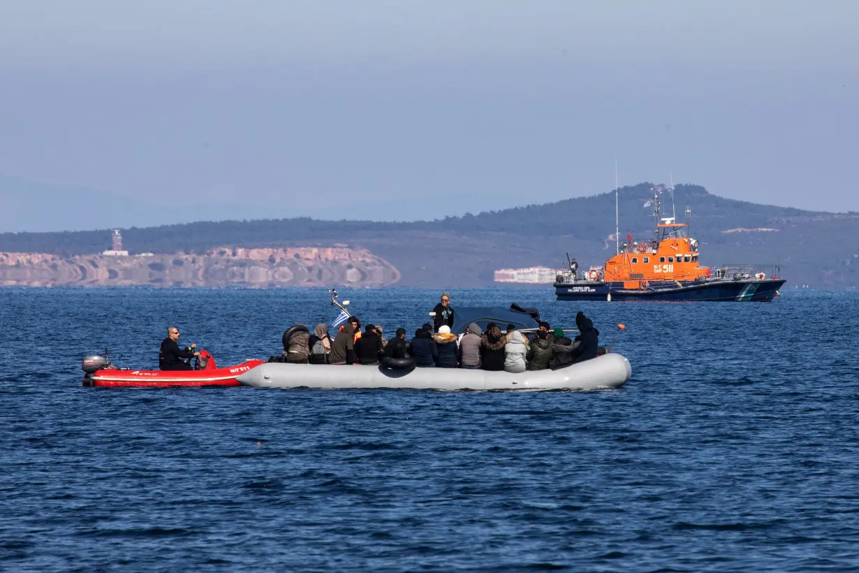 Migrants on a dinghy with a damaged engine are helped by coast guard rescuers to reach the port of Thermi, as they cross part of the Aegean Sea from Turkey to the island of Lesbos