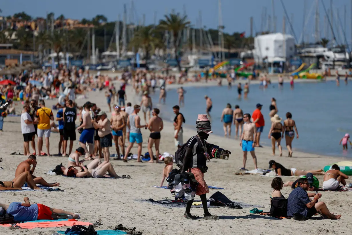 Tourists sunbathe in El Arenal beach in Palma de Mallorca, Spain.