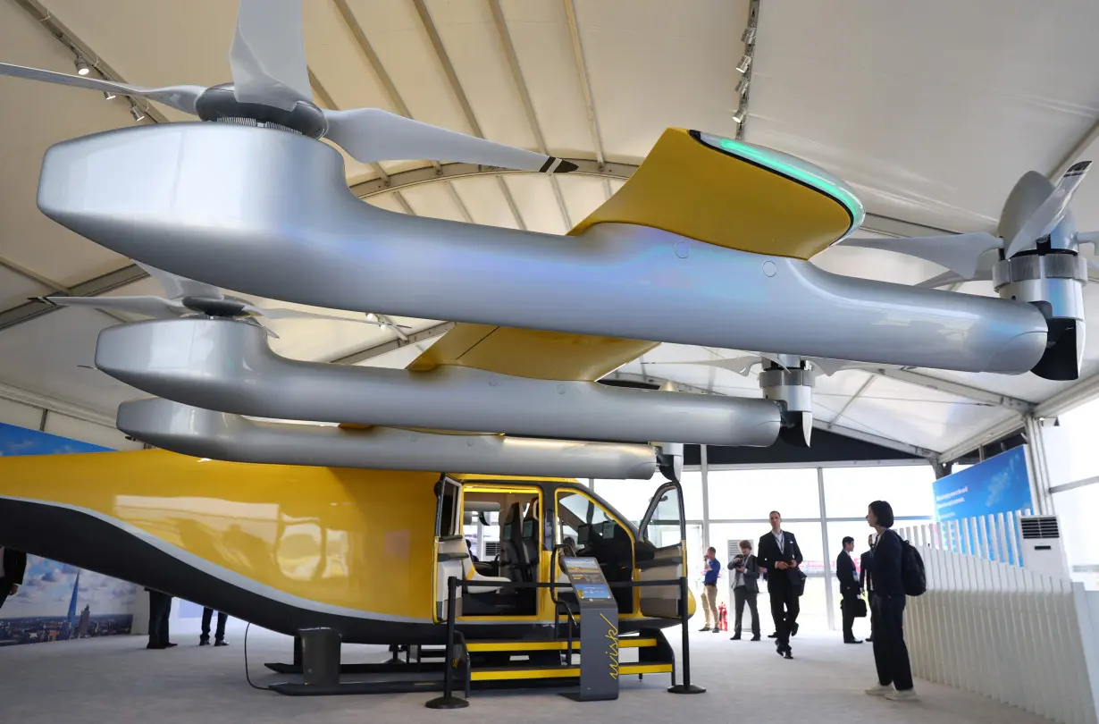 Attendees view a Wisk autonomous electric air taxi at Farnborough International Airshow, in Farnborough