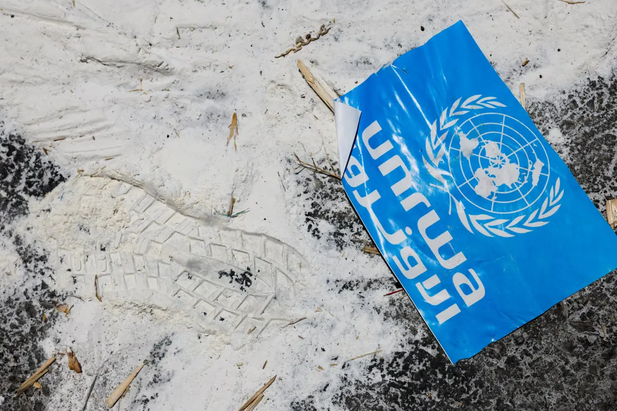 FILE PHOTO: A United Nations Relief and Works Agency (UNRWA) sign lies on the ground, amid the ongoing conflict in Gaza between Israel and the Palestinian Islamist group Hamas, at the Kerem Shalom crossing in southern Israel