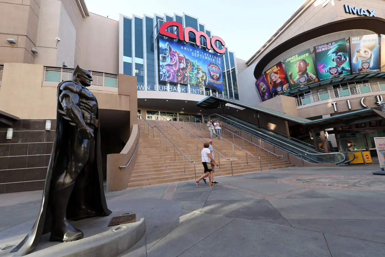 People walk by an AMC theatre in Burbank