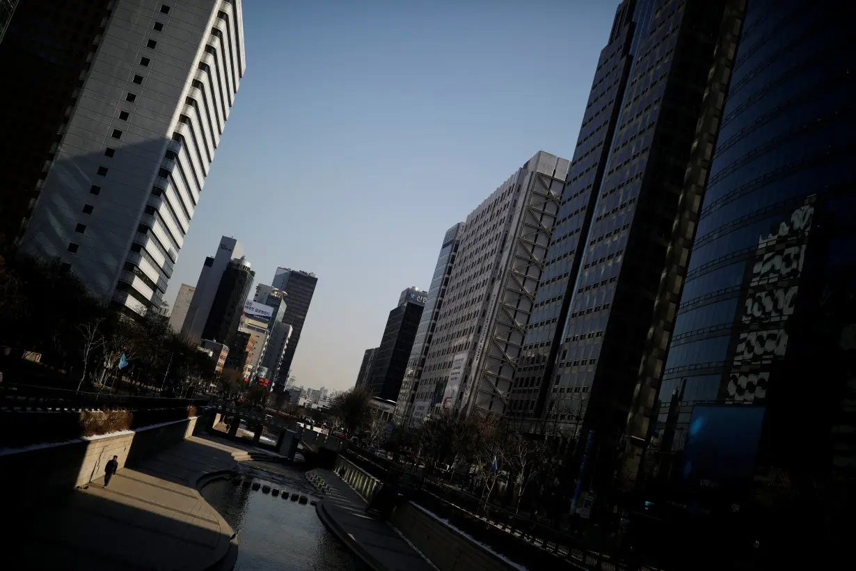 FILE PHOTO: A man walks along the Cheonggye stream in central Seoul