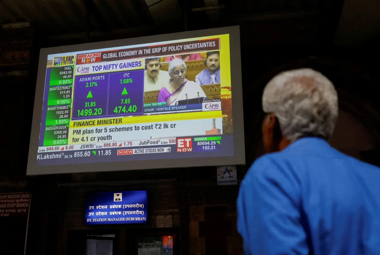 A man watches a screen displaying India's Finance Minister Nirmala Sitharaman's budget speech at a railway station in Mumbai