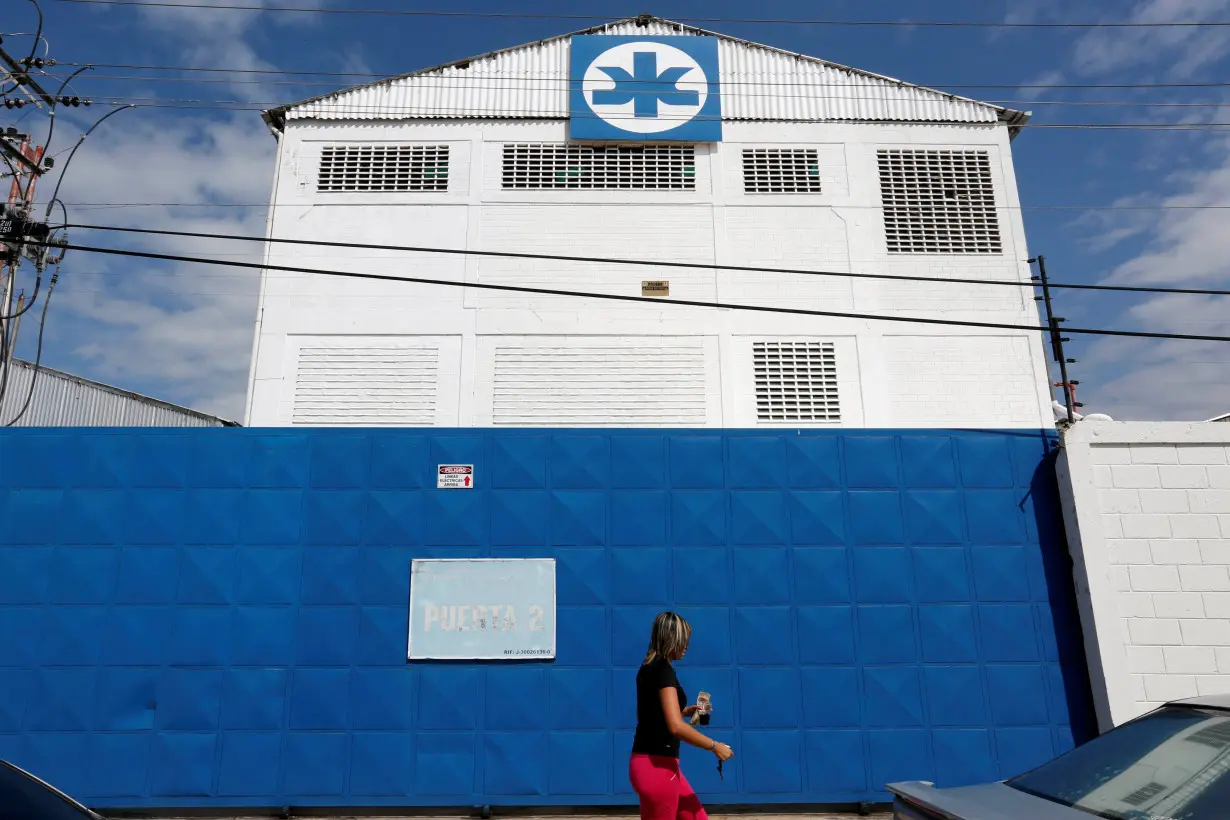 A woman walks outside a Kimberly-Clark building in Maracay