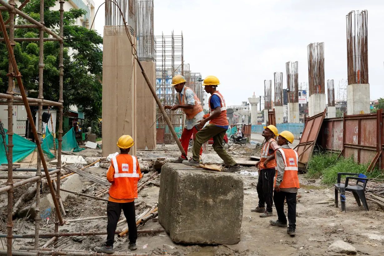 Workers erect a scaffolding to build a pillar at a rail line construction site in Kolkata