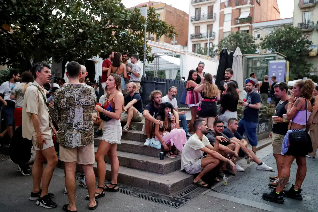 FILE PHOTO: Tourists and residents drink on a street in Gracia neighbourhood during a heatwave of the summer, in Barcelona