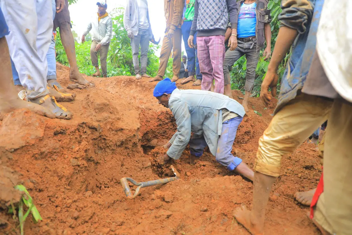 A man searches for survivors as people gather at the site of a landslide in the Kencho Shacha Gozdi district of Gofa Zone, in southern Ethiopia, on July 22.