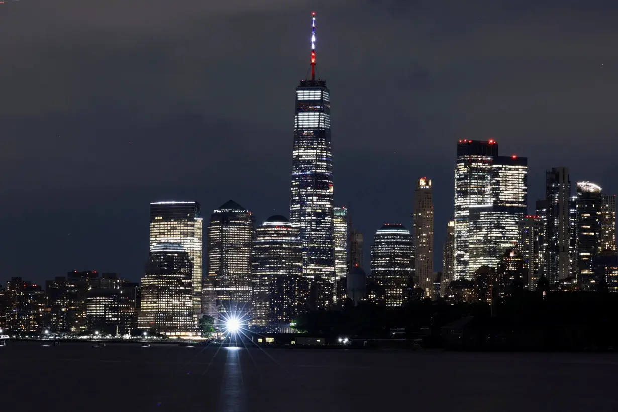 A long exposure picture shows the One World Trade Center building peaking through the Manhattan skyline, as seen from New Jersey