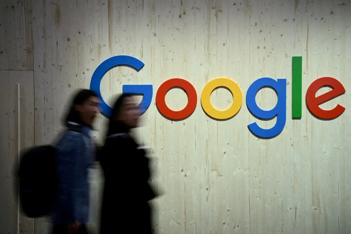 FILE PHOTO: People walk next to a Google logo during a trade fair in Hannover Messe