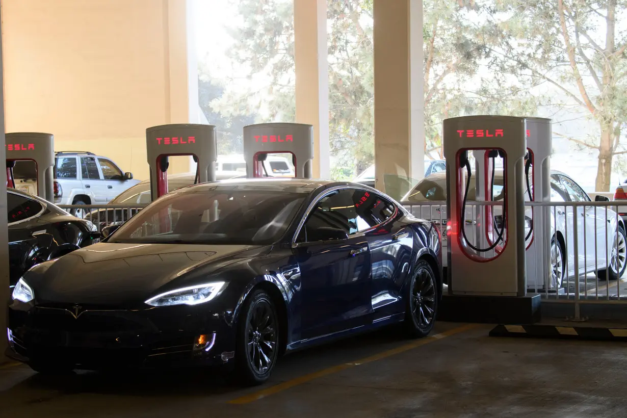 Tesla disappoints Wall Street despite strong profits. Image shows Tesla electric vehicles charge at a supercharger station on January 4, 2021 in Redondo Beach, California.