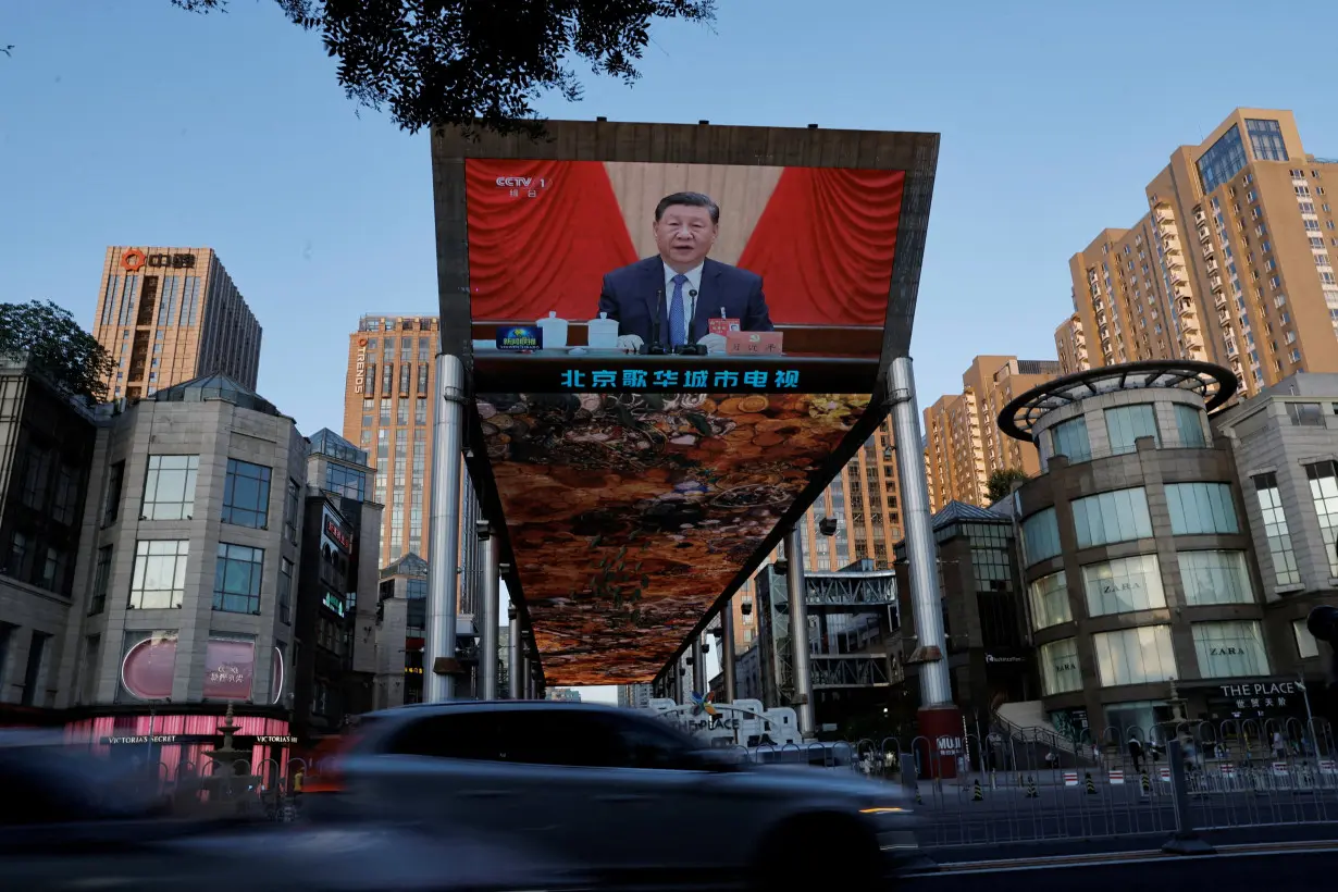 FILE PHOTO: Giant screen shows news footage of the third plenary session of the 20th Central Committee of the Communist Party of China (CPC), in Beijing