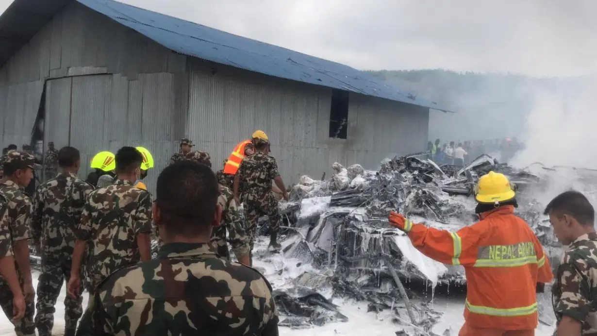 Rescuers gather at burnt wreckage of crashed aircraft, in Kathmandu