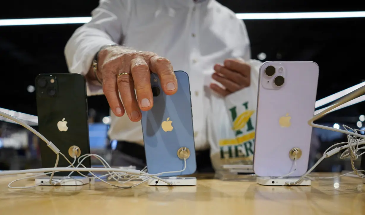 A man looks at Apple iPhones at a shop in Bilbao